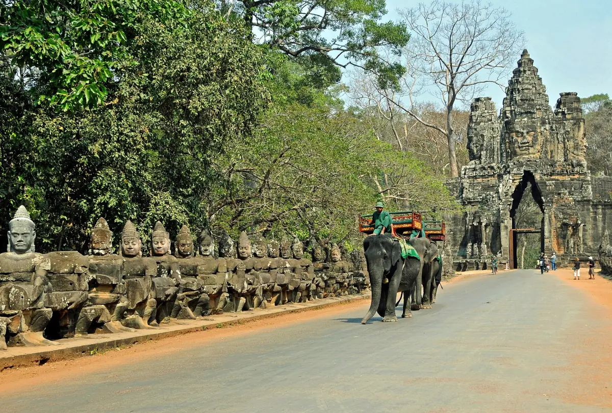 South gate of Angkor Thom at the end of a causeway lined with stone figures